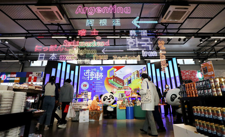 在上海市南京路上的进博集市内，顾客们走在一处各国商品集中展示台前（2021年11月8日摄）。新华社记者 方喆 摄
