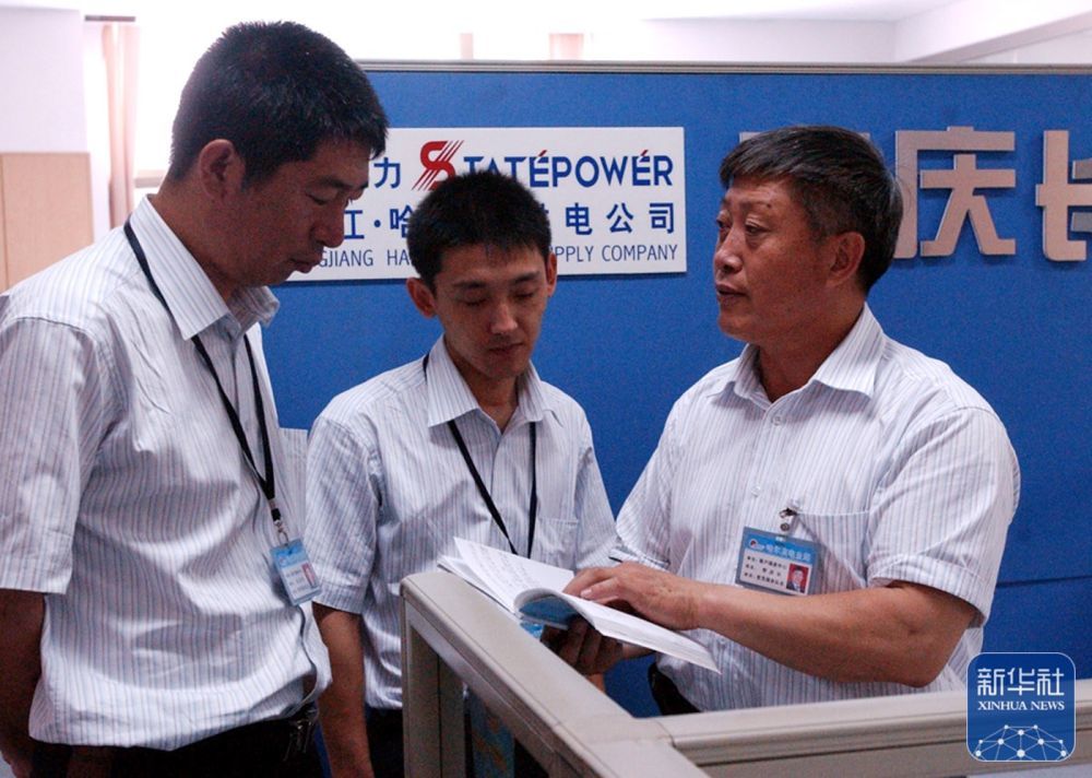 李庆长(右)在与服务队的队员研究工作(2004年7月1日)。新华社记者 李勇 摄