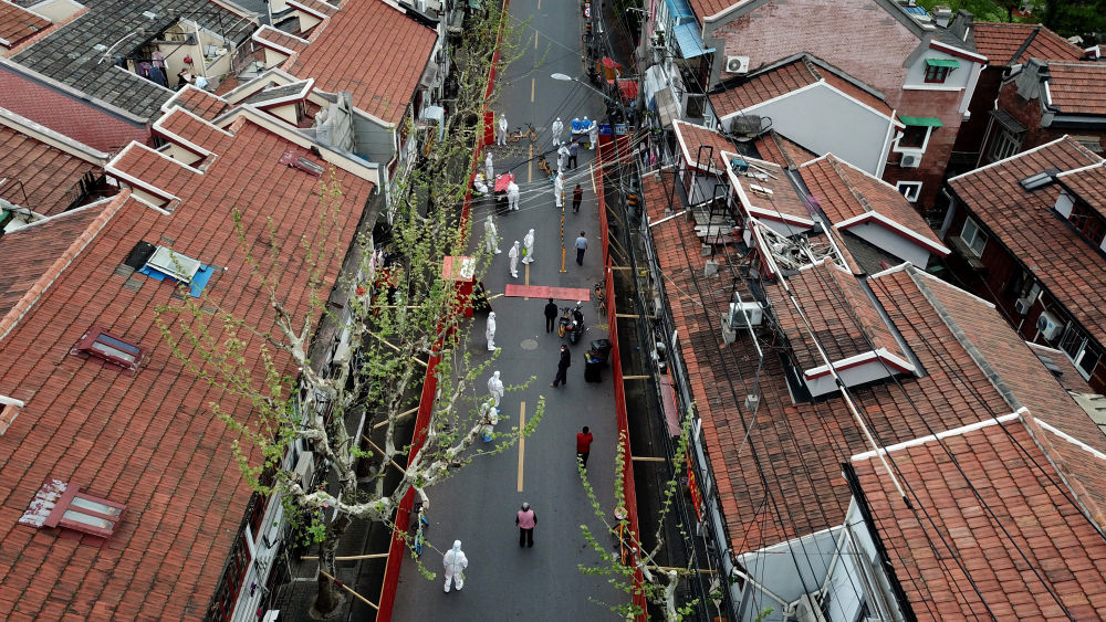 ↑4月10日,在上海市黄浦区蓬莱路一封控社区,居民排队接受核酸采样(无人机照片)。