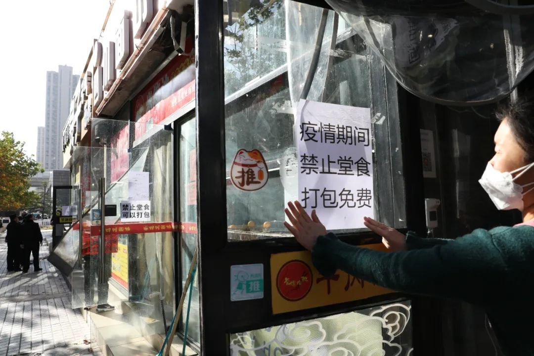 ▲2022年11月21日，北京朝阳区南磨房乡某餐饮店在张贴“禁止堂食，打包免费”的告示。新京报记者 王飞 摄