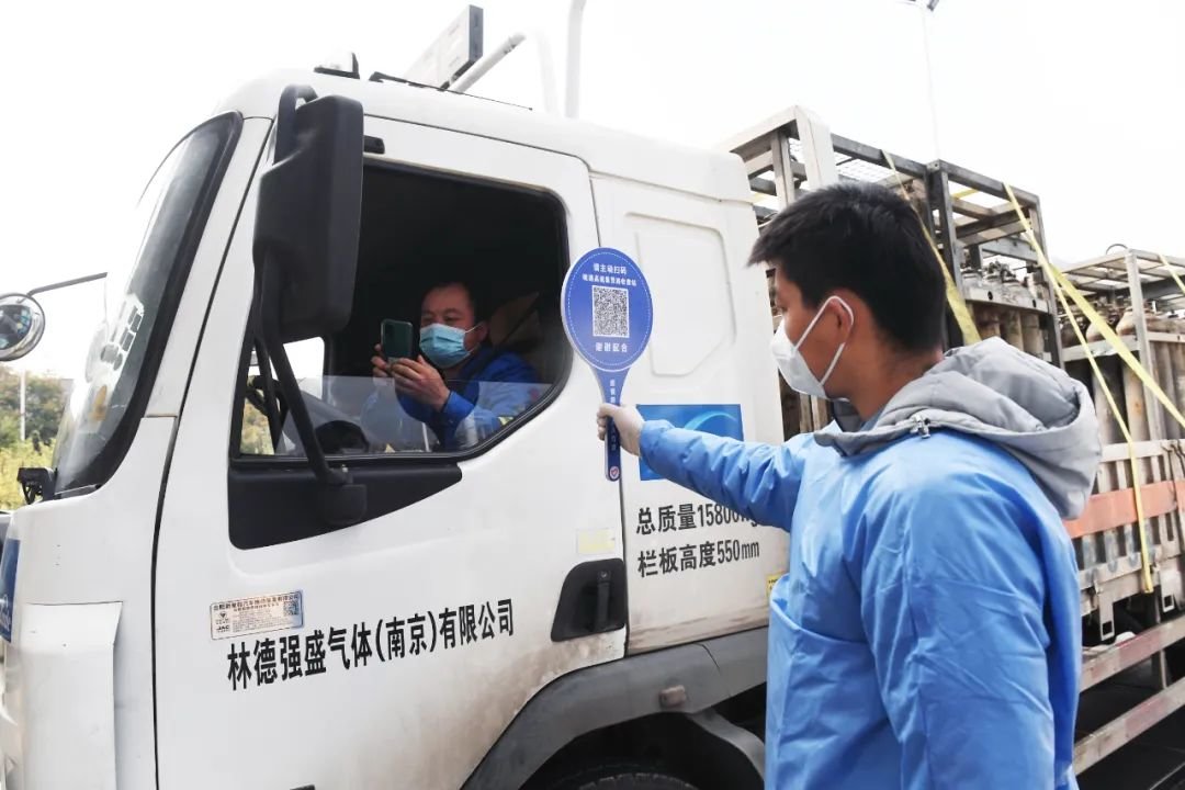 11月24日,在集贤路高速道口,工作人员在对货车司机进行“两码”核验。全媒体记者 郭如琦 摄