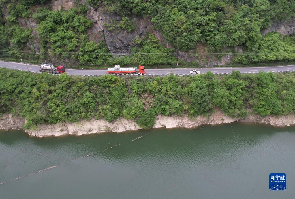 4月14日,在石泉縣曾溪鎮漢江邊的國道上,交警警車護送危化品運輸車輛