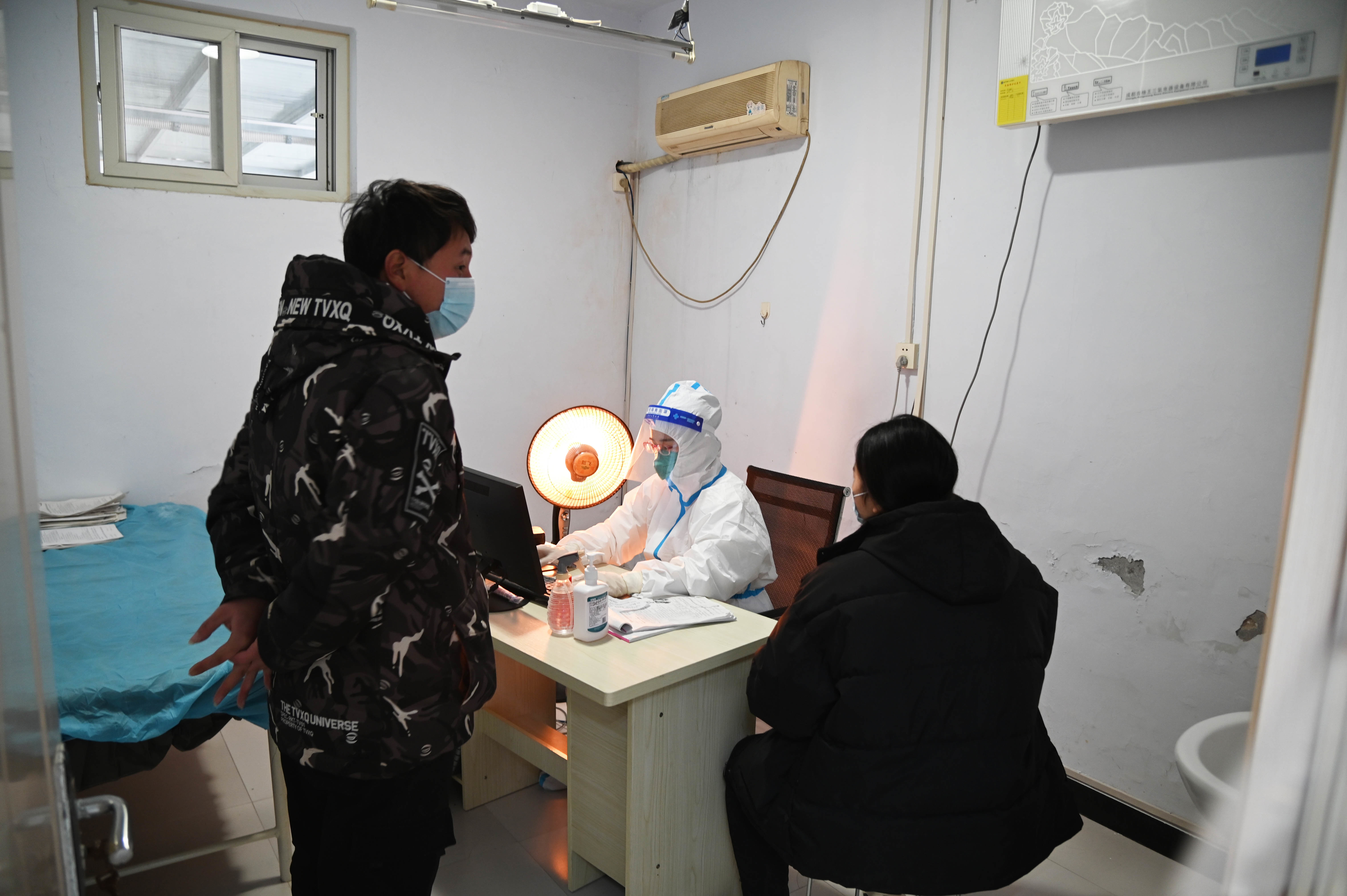 12月18日，在新乡市延津县人民医院发热门诊儿童诊室，发热患者正在与医护人员交流。（新华社记者 张浩然 摄）