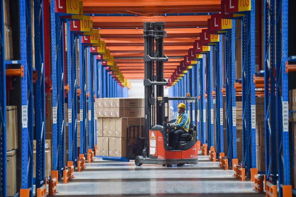 在位于江苏省南京市江宁区的苏宁华东物流中心,工人驾驶叉车搬运商品