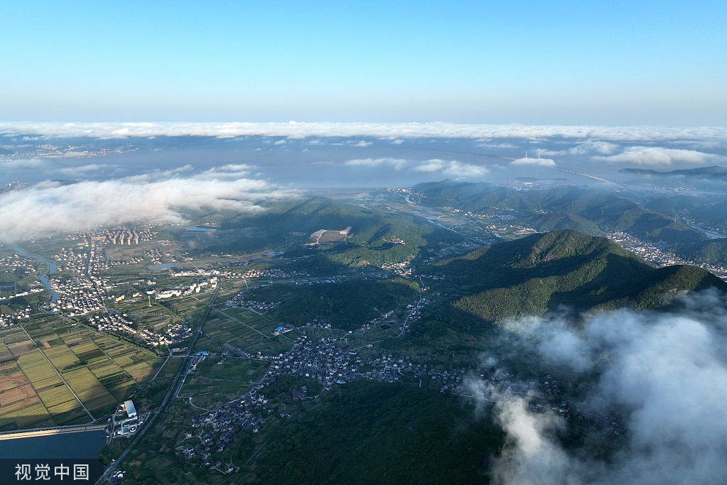 2022年5月6日，浙江省舟山市定海区金塘岛仙人山顶，晨雾弥漫，晨光照射云层，尽染海岛风光。