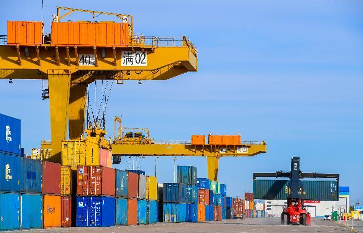 ↑作业车辆在满洲里口岸铁路集装箱场内装卸集装箱。新华社记者彭源 摄