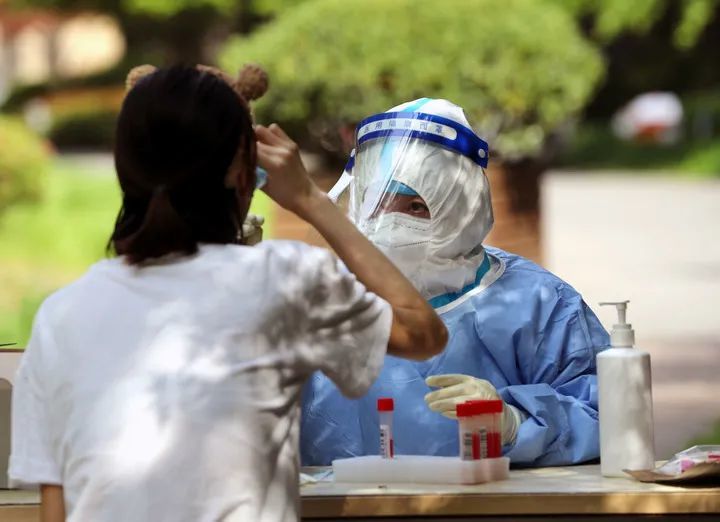 4月12日，在上海松江区一被列为封控区的居民小区内，医务人员在进行核酸检测采样。新华社记者 刘颖 摄
