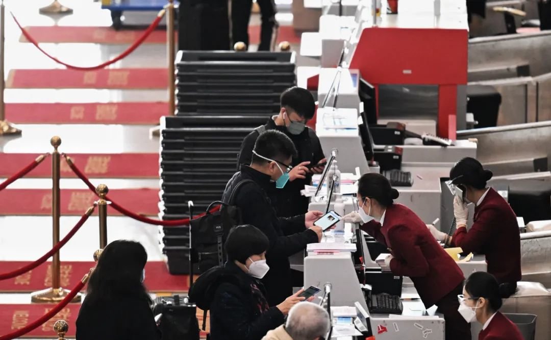 ▲2022年11月22日，北京首都机场，旅客办理值机时工作人员核验核酸证明。新京报记者 陶冉 摄