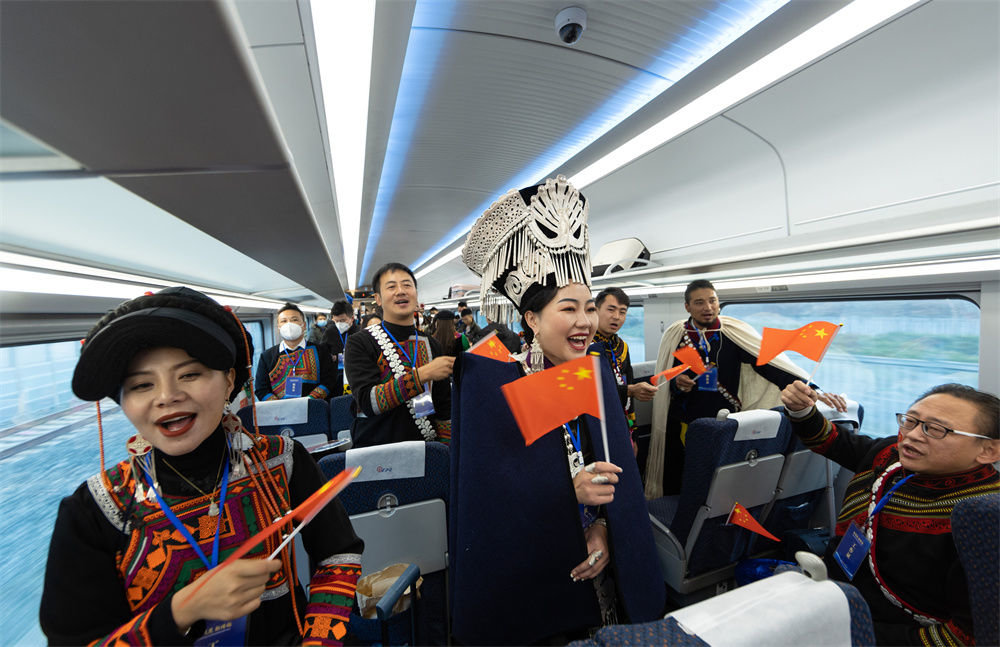 12月26日，彝族群众身着节日盛装在新成昆铁路首发列车上为乘客表演节目。新华社记者 江宏景 摄