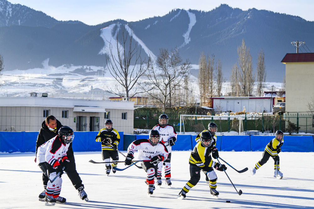 ↑新疆乌鲁木齐市乌鲁木齐县第一中学小学部冰球队的学生在进行冰球比赛（2022年1月12日摄）。