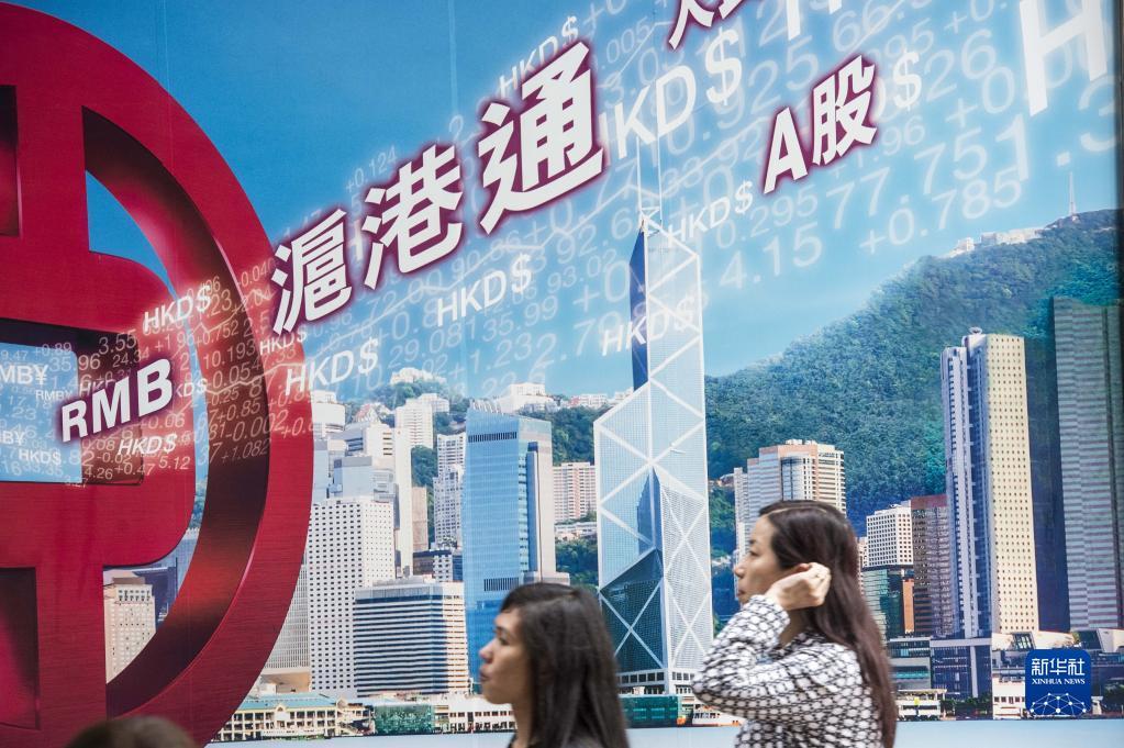 市民从香港中环一家银行的沪港通广告牌前走过（2015年4月8日摄）。新华社记者吕小炜摄
