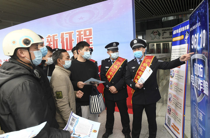 在广西南宁东站，南宁铁路公安处民警向旅客宣传防电信诈骗常识（2022年1月9日摄）。新华社记者 陆波岸 摄