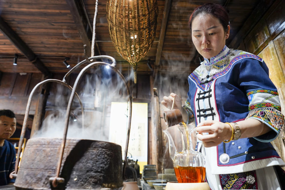 2021年5月13日，在重庆市石柱县中益乡的老鹰茶工作室内，茶艺师在为前来选购茶叶的游客烹煮老鹰茶。新华社记者刘潺摄
