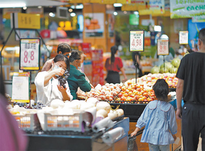 江西鹰潭市余江区在做实做细疫情防控工作的同时,组织商场、超市增加米面粮油、肉禽蛋奶等主副食品备货,让市民放心选购货品。图为市民在超市选购蔬菜水果。左云华摄