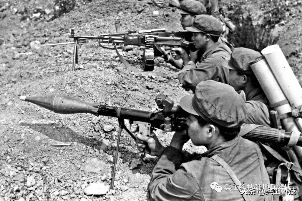 近处为手持69式火箭筒的发射手,稍远处是背负火箭弹的弹药手