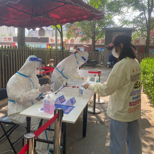 5月9日，北京市朝阳区炫特社区核酸检测现场，医务人员正在进行身份信息登记。殷春艳摄