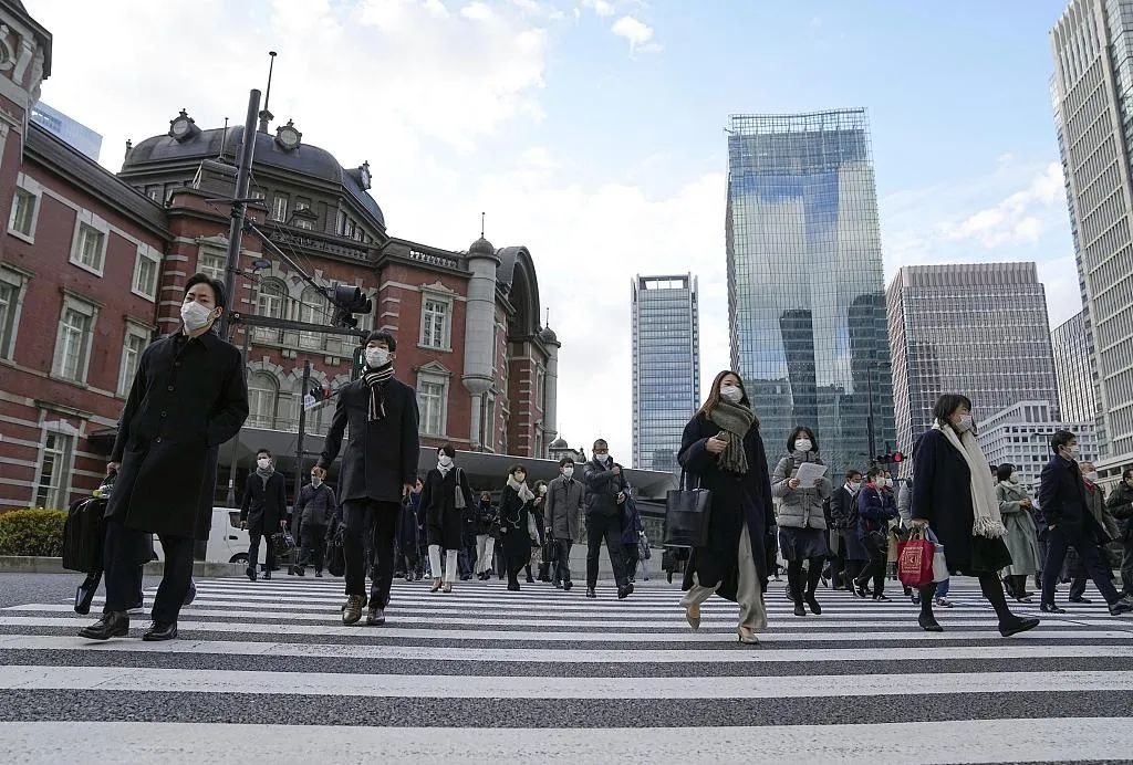 当地时间2022年12月28日,日本东京站前,戴着口罩上班的上班族在2022年的最后一个工作日上班。图/视觉中国