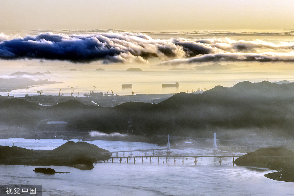 2022年5月6日，浙江省舟山市定海区金塘岛仙人山顶，晨雾弥漫，晨光照射云层，尽染海岛风光。