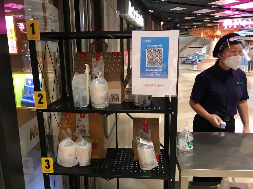 工作人员正在麦当劳bfc外滩金融中心门店外的"无接触"外卖取餐台边