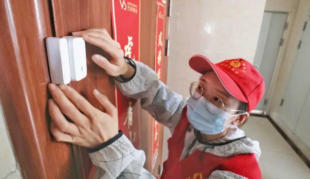 在蜀山区五里墩街道清溪路社区青秀城小区,志愿者为居家隔离人员配备智慧门磁系统设备。宋炎骏 摄(资料图)