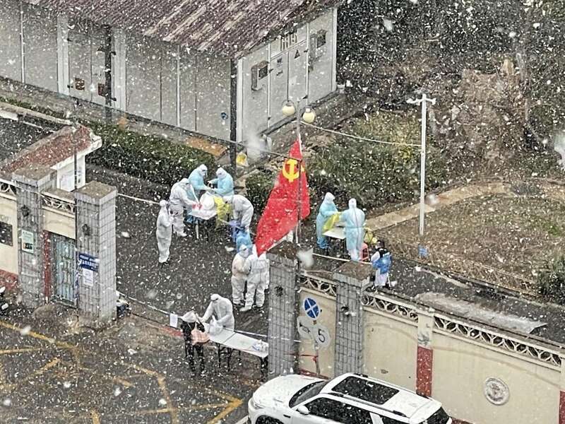 天大雪中,党员志愿者正在为居民核酸检测做准备。(信若一/摄)