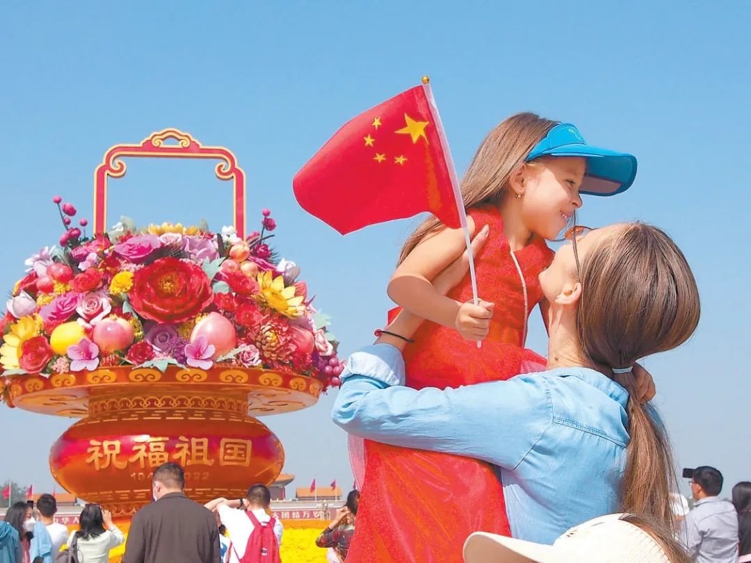 天安门广场上，一对母女在“祝福祖国”巨型花果篮前拍照留影。本报特约摄影 杜建坡