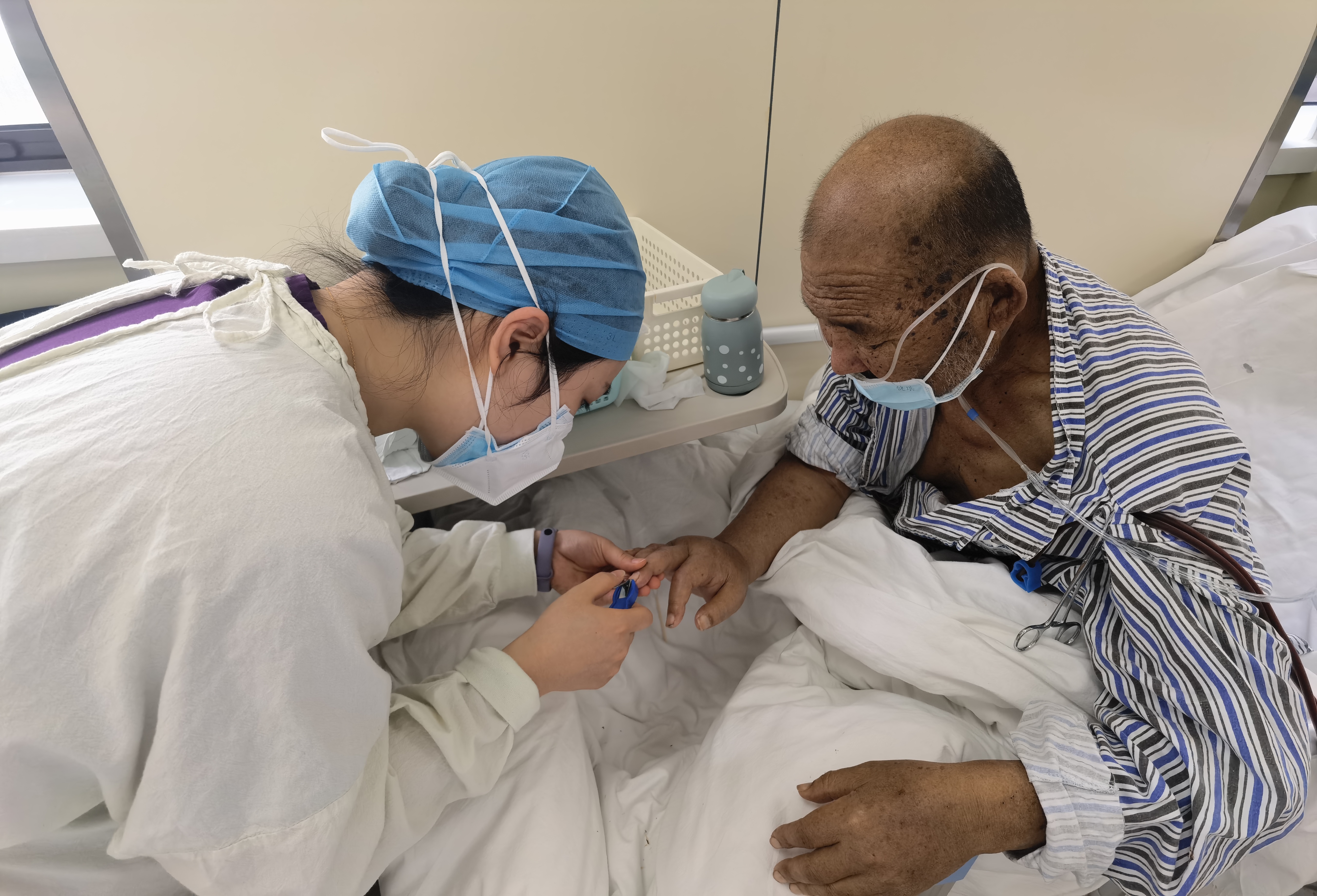 5月4日，血液净化中心护士罗笛在为患者剪指甲。受访者供图