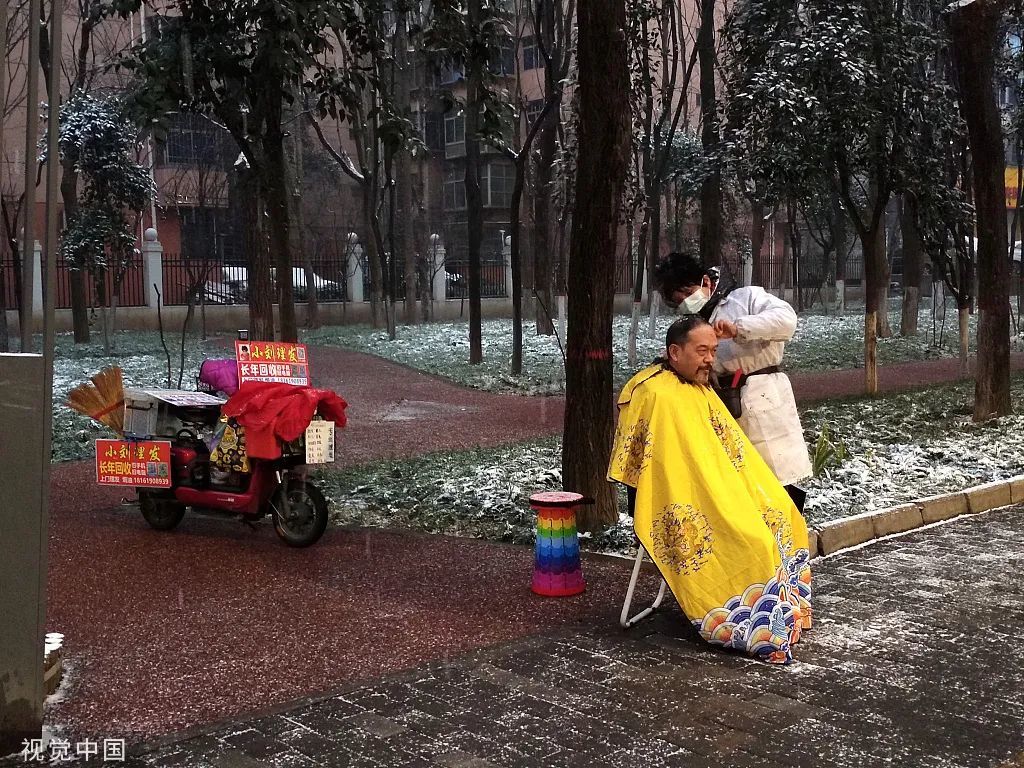 2022年2月7日，陕西省西安市气温骤降，一名长年游走在经九路早市的理发师小刘顶着飞雪“开门营业”。早上7点50分左右，第一位顾客光临惠顾。