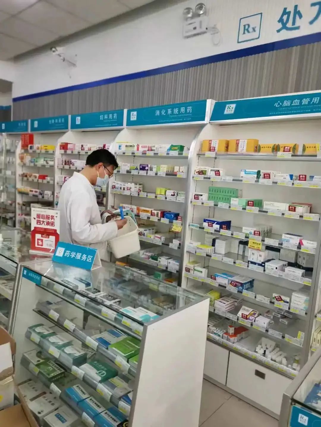 李中州在货架前根据订单拿药 参考资料：新京报