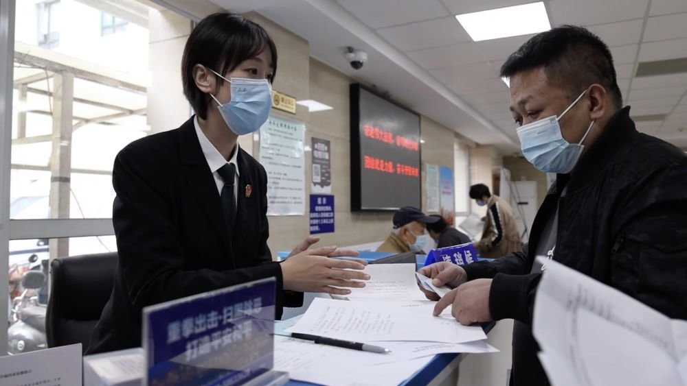 在天津市和平区人民法院,工作人员(左)为群众讲解“菜单化”多元解纷流程(2022年11月21日摄)。新华社记者 李帅 摄