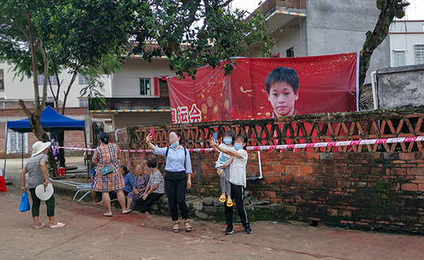 去年8月8日，广东湛江麻章区迈合村，游客在全红婵家门口自拍留念。