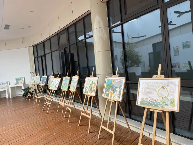秦岭植物园科普教育馆活动中心摆放着学生们以生态保护为主题的绘画作品。(王爽宇 摄)