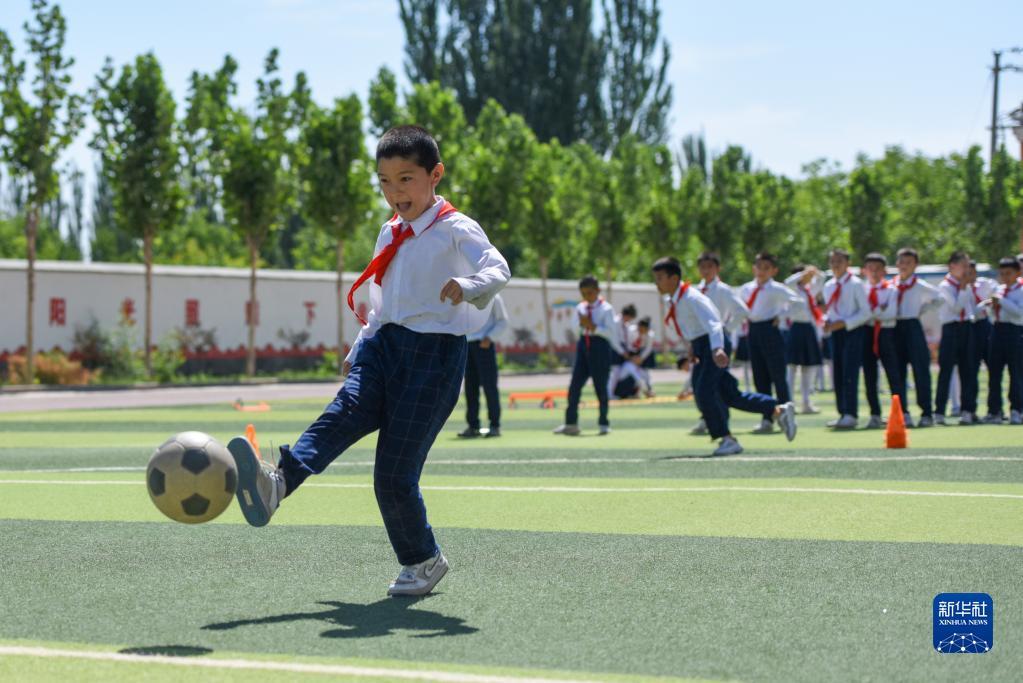 在新疆喀什地区疏附县托克扎克镇中心小学，学生们在上体育课（2022年6月10日摄）。新华社记者 丁磊 摄