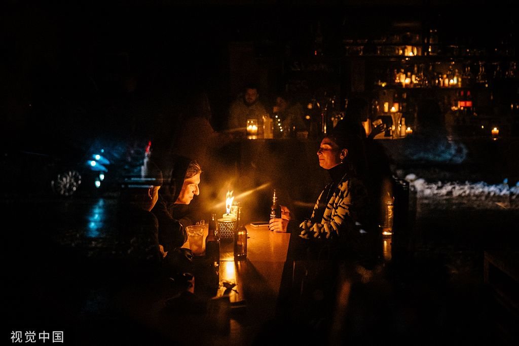 当地时间2022年12月16日，乌克兰基辅，在针对电力基础设施的空袭后，人们坐在基辅市中心一家酒吧的烛光桌旁。