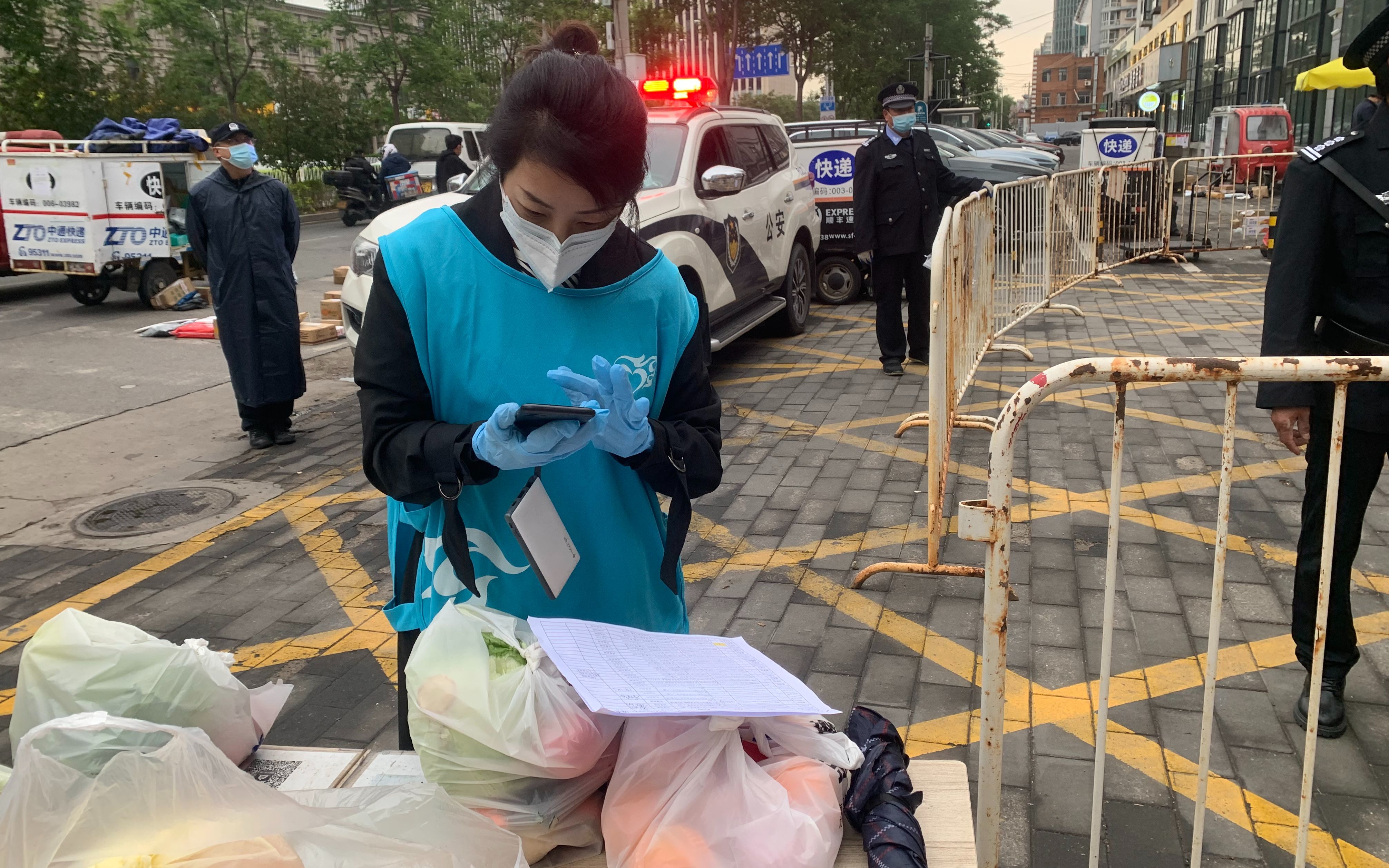 兰珊在风度柏林小区门口联系居民来领菜。受访者供图