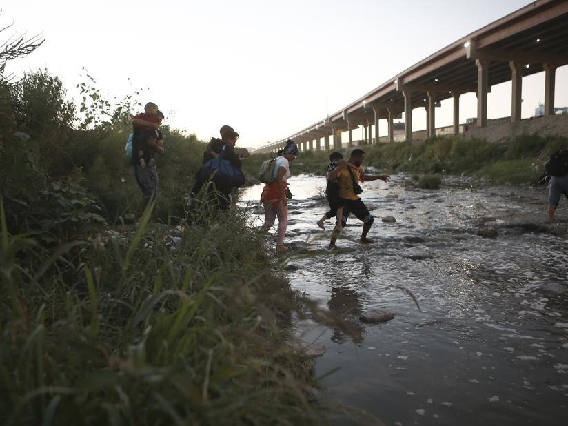 10月13日，几名委内瑞拉非法移民正穿越美墨边境界河。（图片来源：美联社）