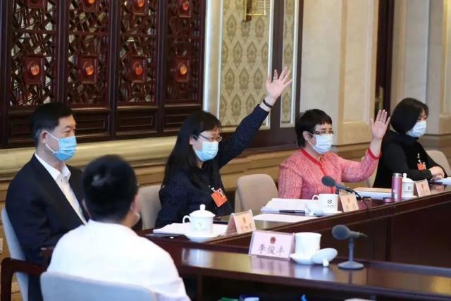 2020年5月，十三届全国人大三次会议期间，全国人大代表冯乐平（右二）在北京代表团小组会上。图源/全国人大