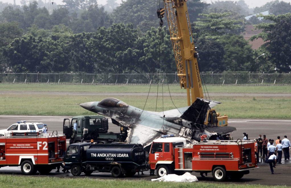 2015年4月16日，在印度尼西亚雅加达哈利姆空军基地，军方救援人员吊起一架被烧毁的F-16战斗机。新华社/欧新中文