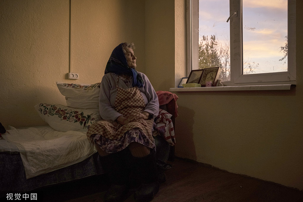 当地时间2022年10月30日，乌克兰切尔尼戈夫，一名妇女在志愿者建造的新房子里拍照。导弹和无人机袭击能源基础设施导致乌克兰电力和供暖中断，这增加了冬季准备工作的紧迫性。