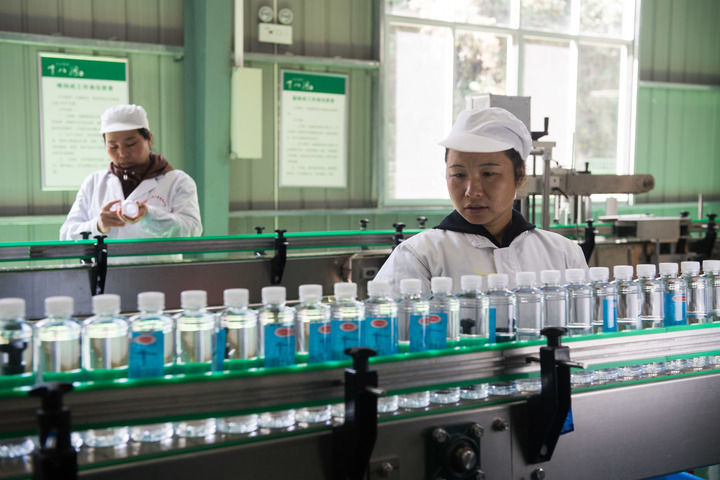 2019年10月29日，在湘西土家族苗族自治州花垣县十八洞村山泉水厂，村民在流水线上工作。新华社记者 陈思汗 摄