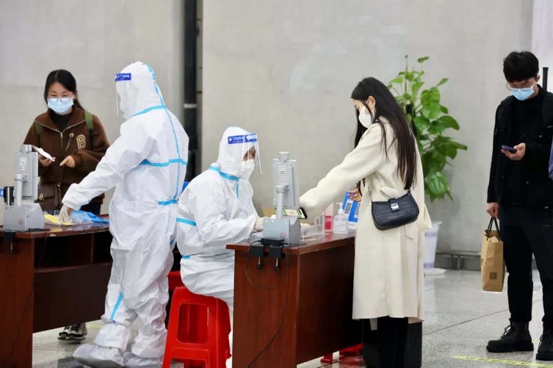 11月23日晚,在合肥南站出站口,工作人员通过全息防疫核验哨兵核验旅客“两码”,提高通行效率。全媒体记者 李予 摄