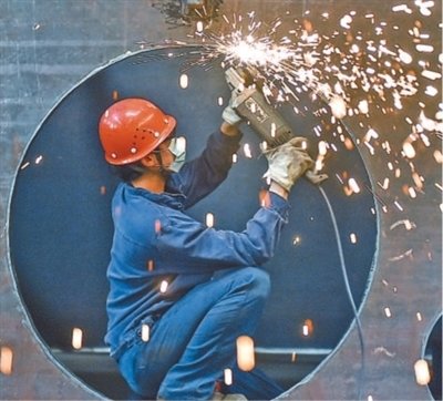 河南省洛阳市，工人在中信重工车间清理打磨出口的矿用磨机筒体。近年来，该公司在矿业及水泥重型装备制造领域深耕，市场影响力不断提升，在“一带一路”沿线订单稳步增加。黄政伟摄（影像中国）