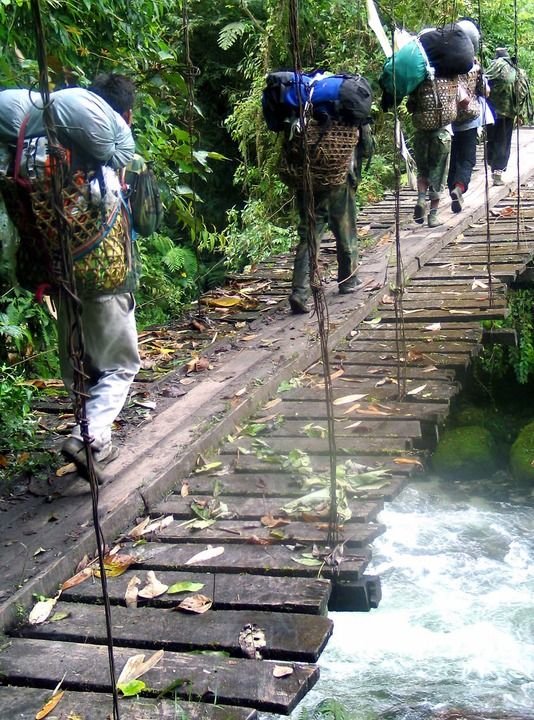2004年10月18日，墨脱当地背夫背着物资通过简易木桥。（资料照片）