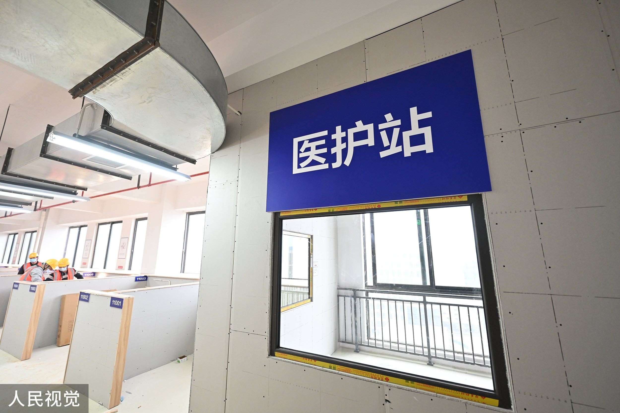 2022年3月31日,上海,在奉贤区在建的集中隔离收治点内,工人师傅正在安装床铺,这是一幢位于产业园区的商办楼,共11层,由原本的办公楼改建,按改造方案可提供500个床位。