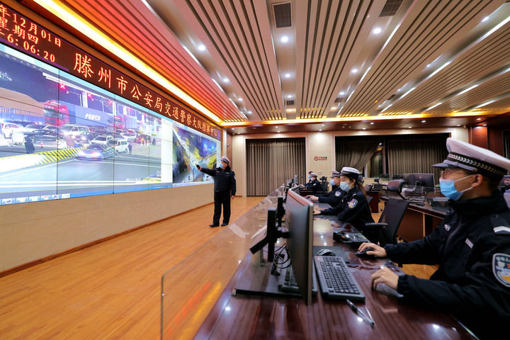 12月1日,在山东省滕州市公安局交警大队指挥中心,借助“情、指、勤、督”一体化智慧交通管理平台,民警对各个路口及路段交通流数据进行综合分析。新华社发(钟自增 摄)