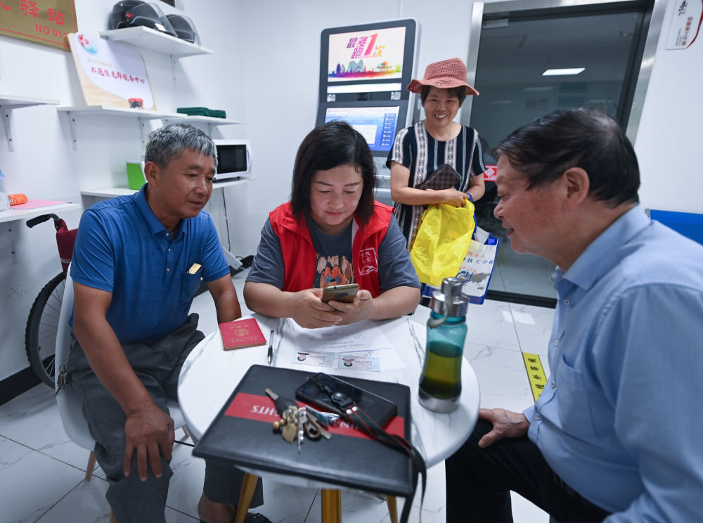 在杭州市临安区玲珑街道东山社区便民服务站，党员志愿者帮助居民填写公租房申请资料（2022年8月17日摄）。新华社记者 徐昱 摄