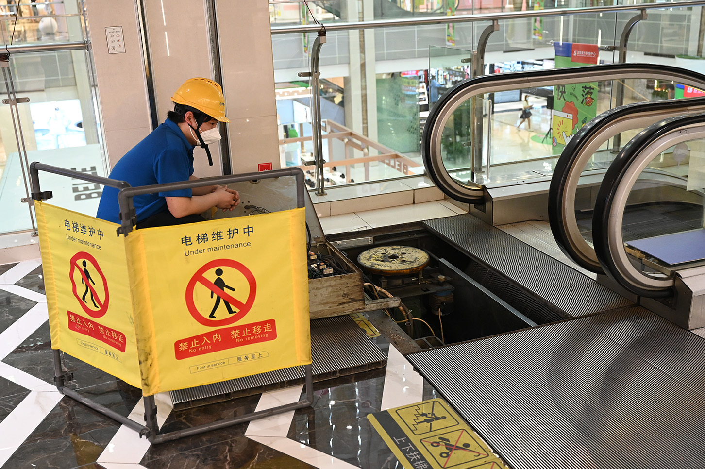 2022年6月1日,上海闵行南方商城里,一位工人在做着电梯维护.