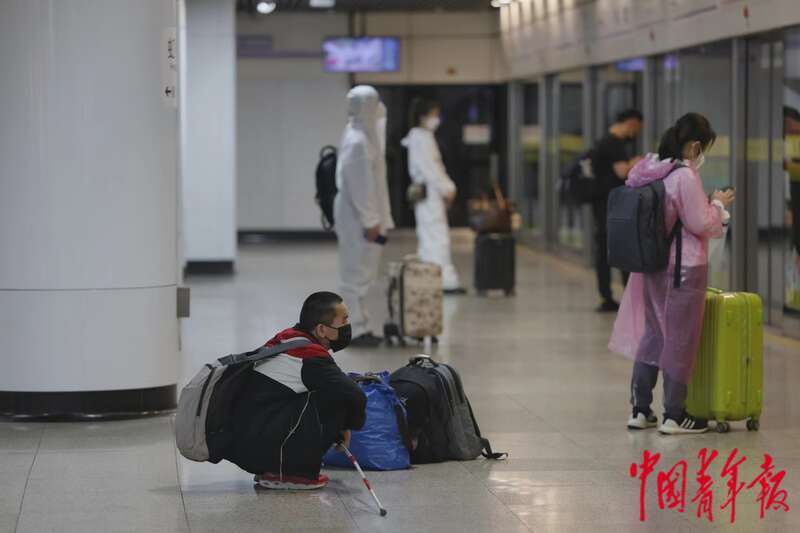 5月22日，上海地铁虹桥路站，一名视力障碍人士正在等待开往虹桥火车站方向的10号线地铁，身边放着他的行李。中青报·中青网记者 李强/摄