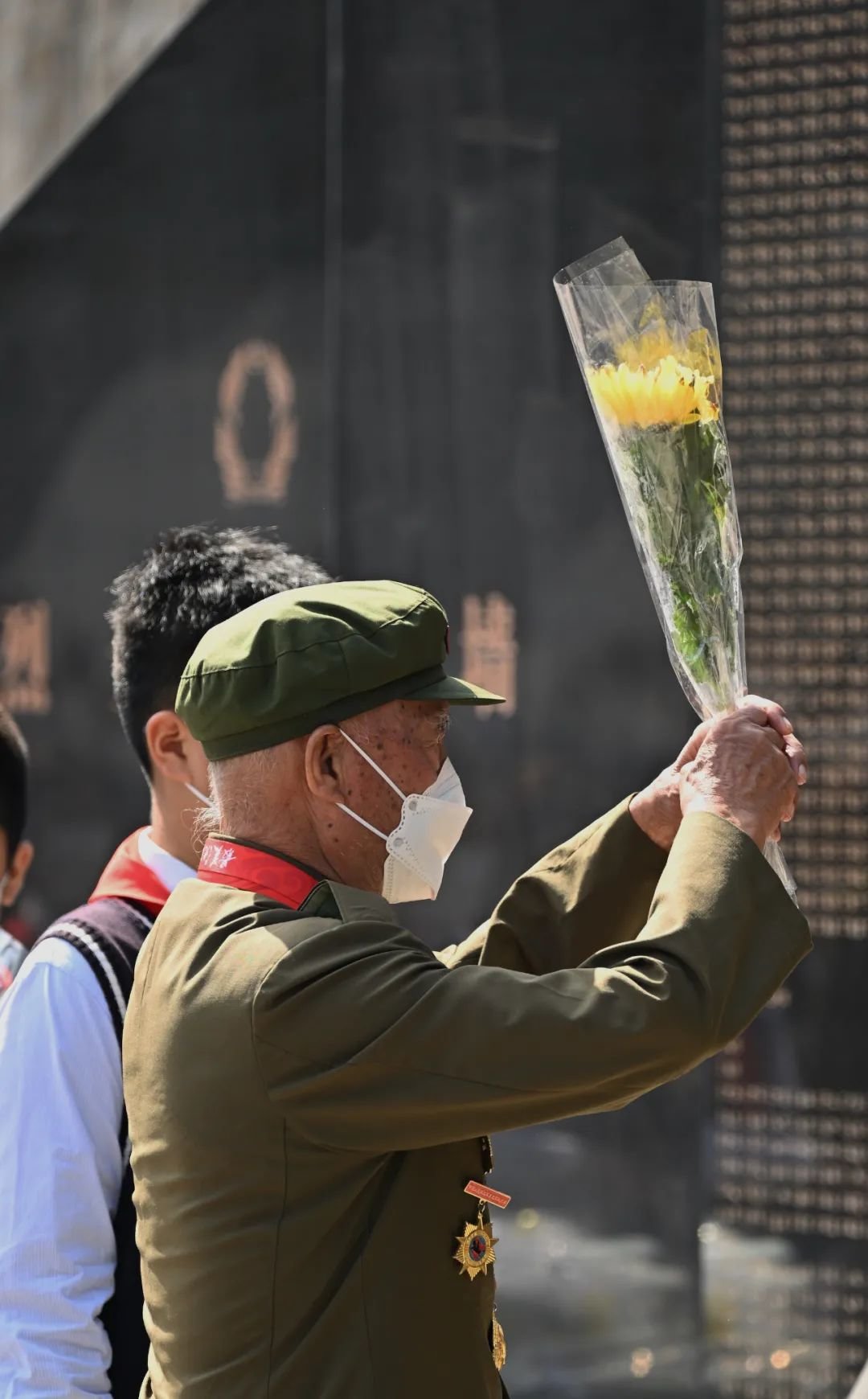 志愿军老兵向牺牲战友献花。