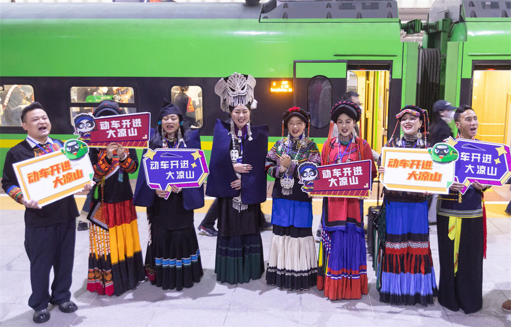 12月26日，在成都南站，彝族群众身着节日的盛装在新成昆铁路首发列车出发前为乘客表演节目。新华社记者 江宏景 摄